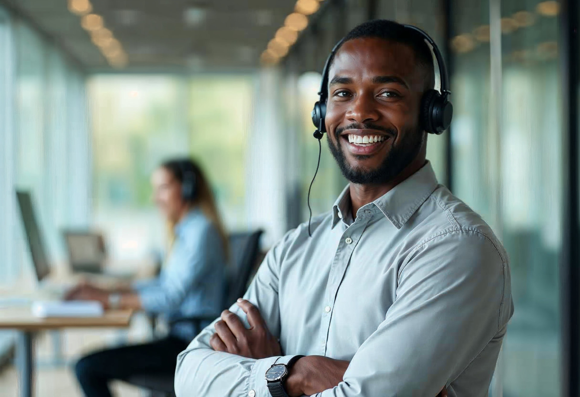 Smiling customer service agent wearing a headset in a modern contact centre